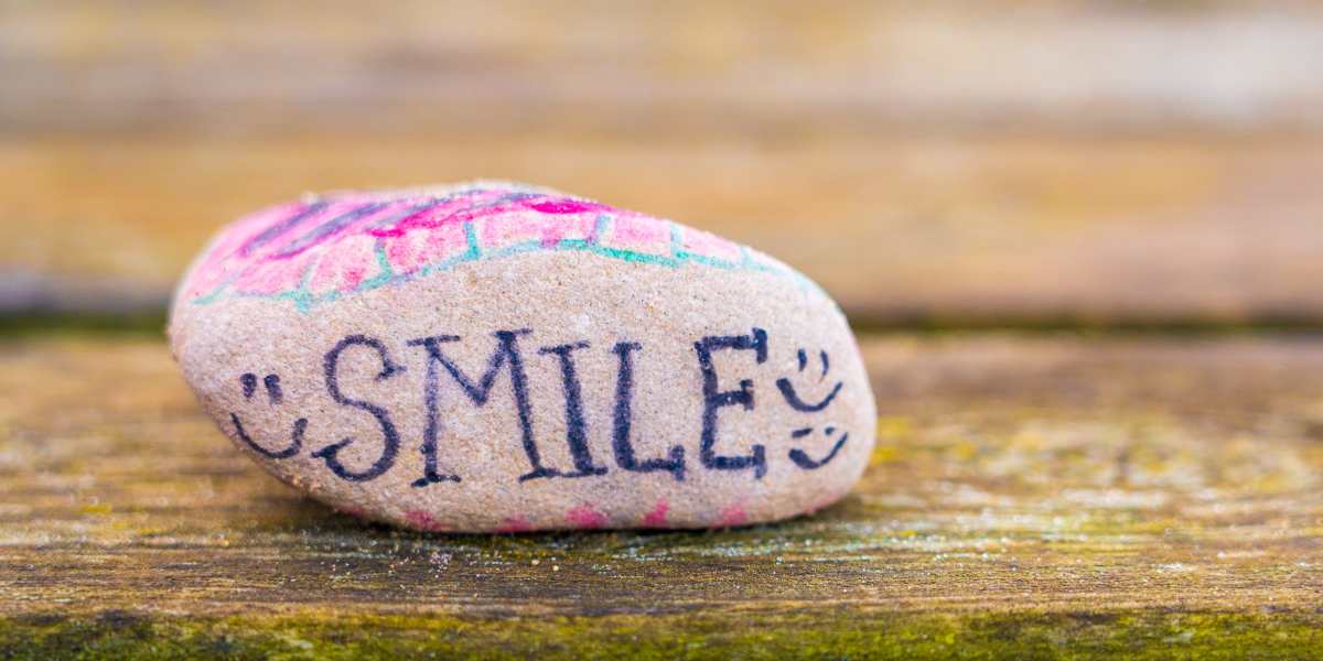A rock with the words smile on it